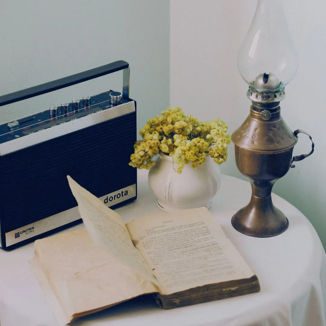 A book with a lantern, a vase, and a radio