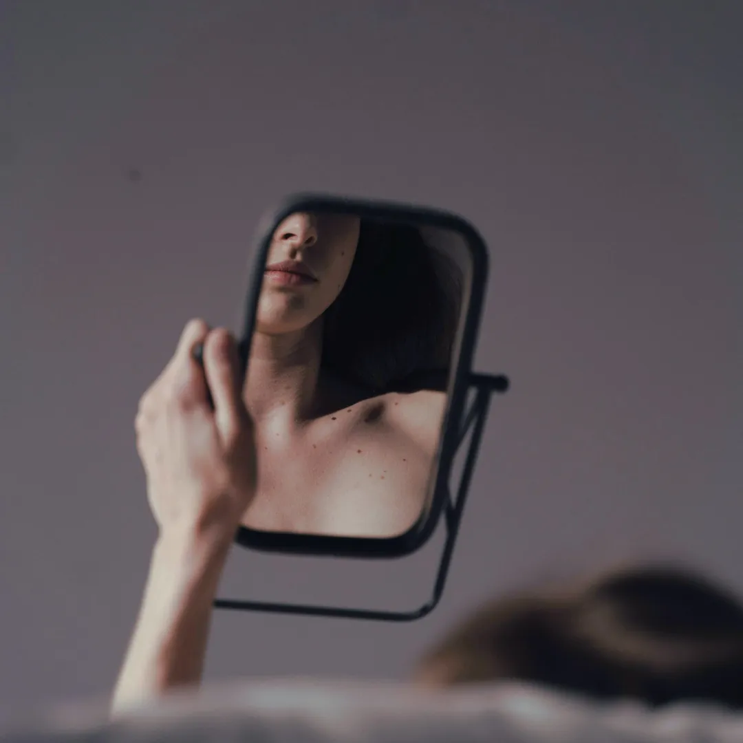 a woman looking at herself in the mirror
