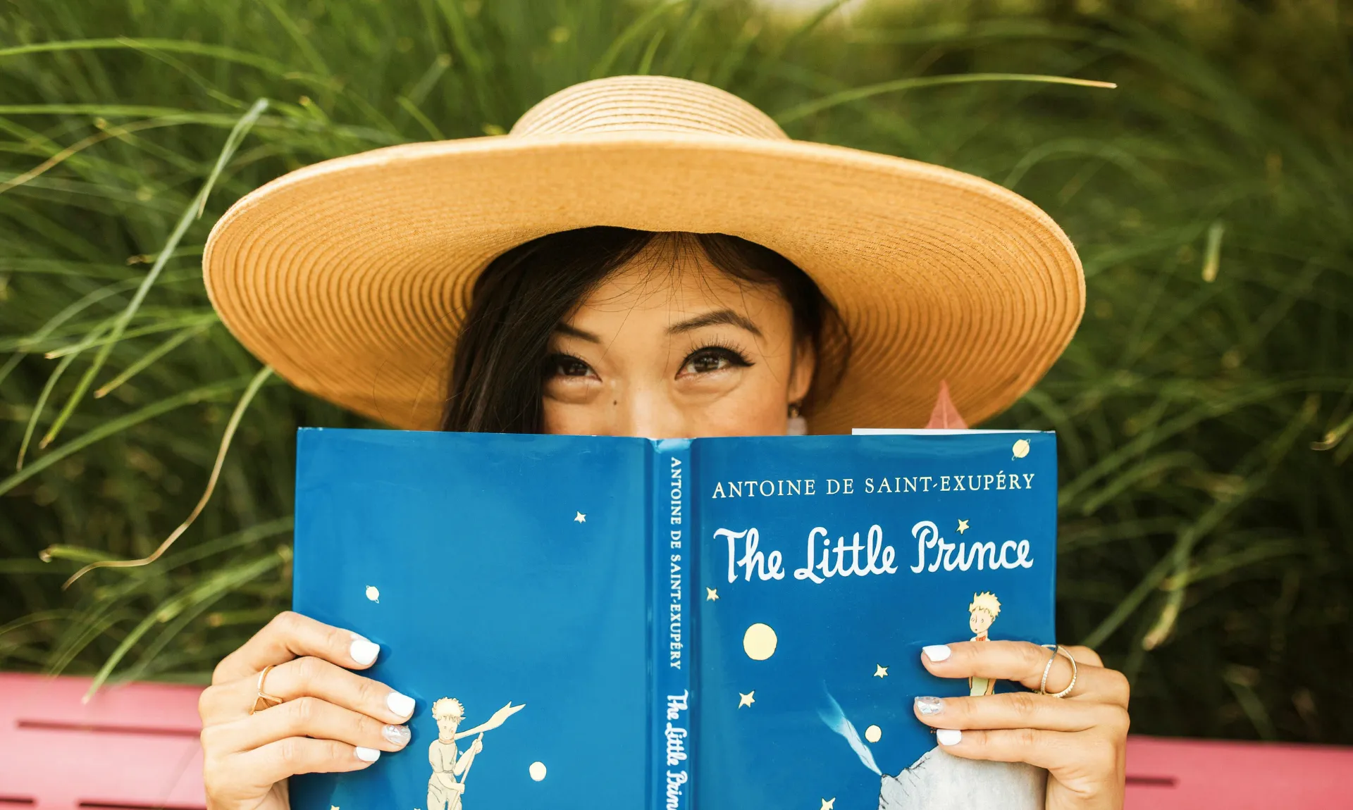 A girl holding copy of The Little Prince by Antoine de Saint‑Exupéry