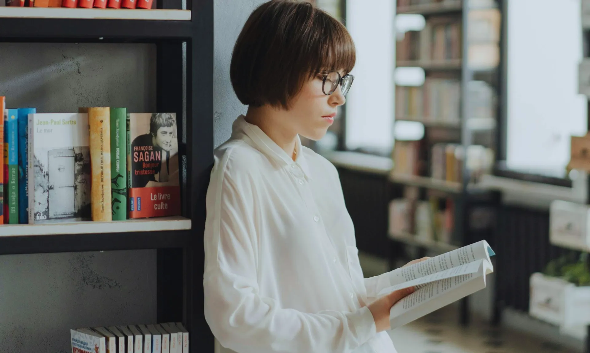 a girl reading a book in the library